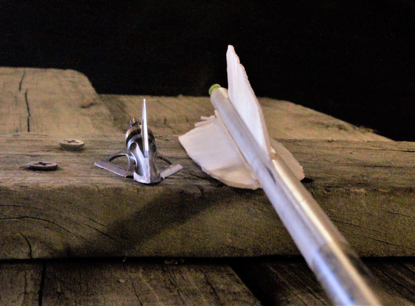 木栅栏上的箭刃和箭羽的图像