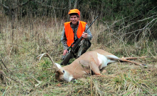 一名猎人与一只死雄鹿合影的照片