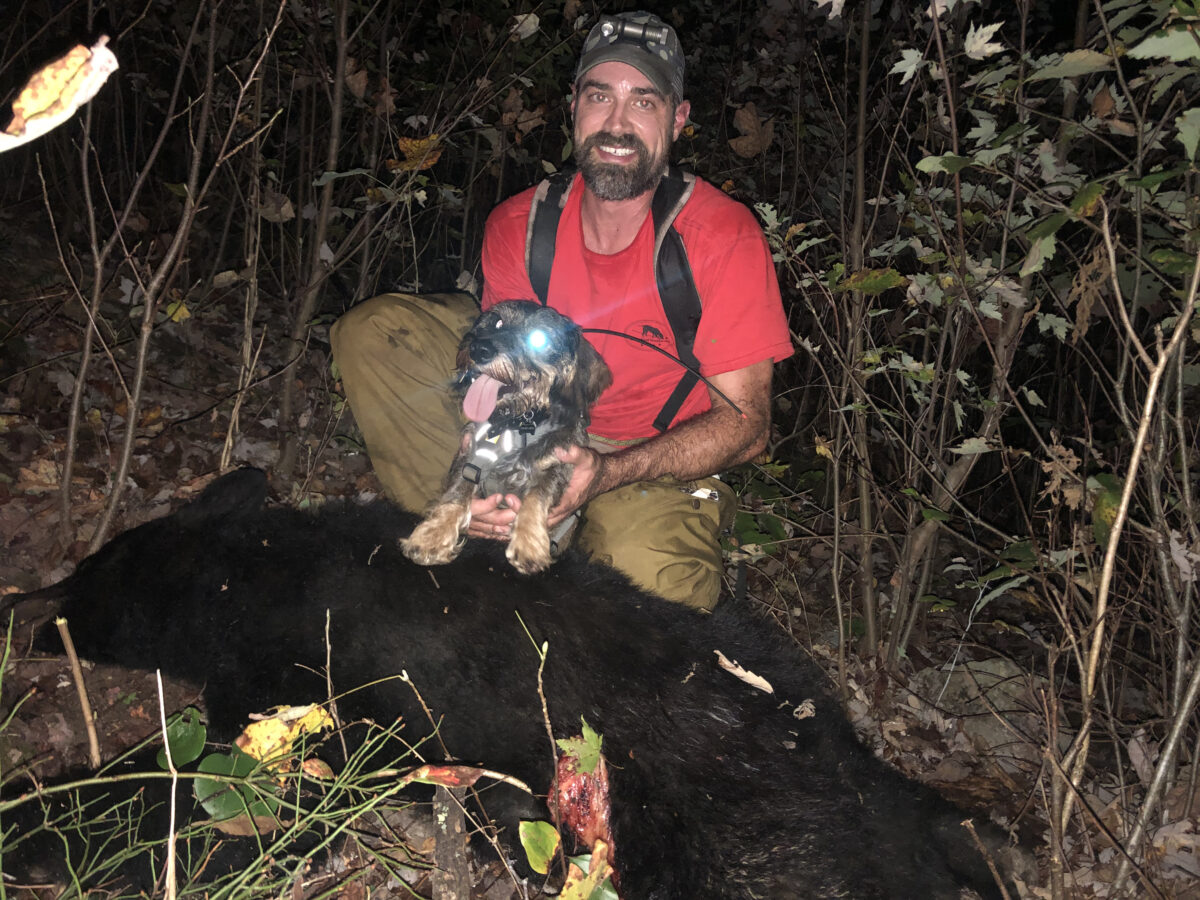 恩佐和布莱尔·史密斯与他们帮助找到的一只熊在一起。 