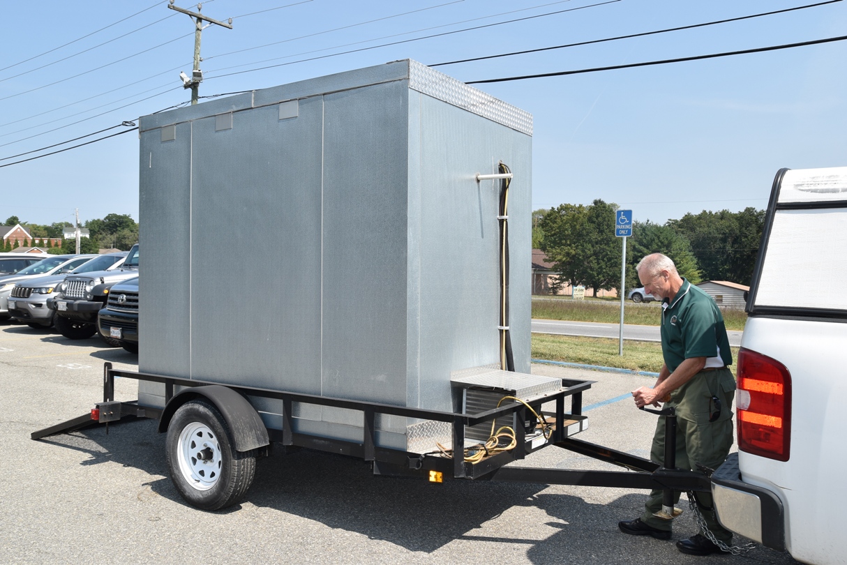 加里·阿灵顿 (Gary Arrington) 和一辆白色卡车后面的 Hunters for the Hungry 移动冷藏箱